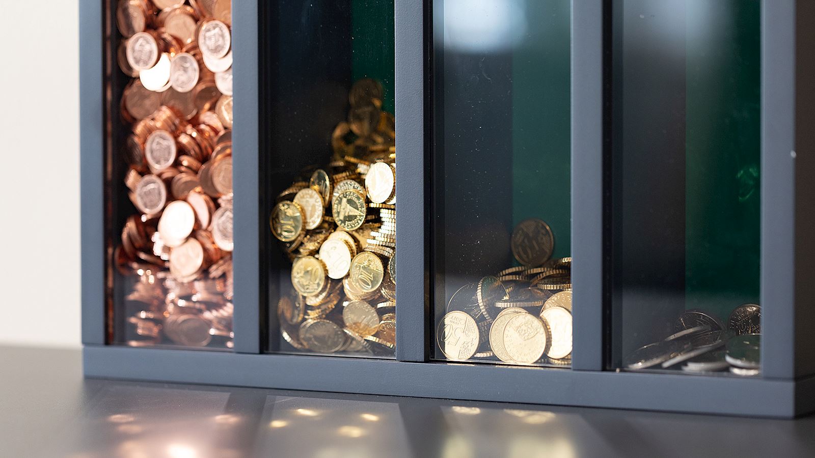 Copper and gold coins in compartment boxes.