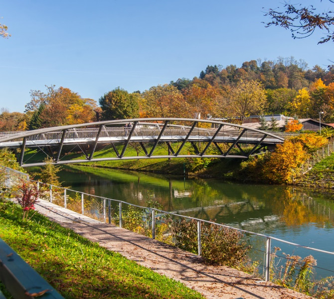 Kolesarski most cez reko, okolica v jesenskih barvah.