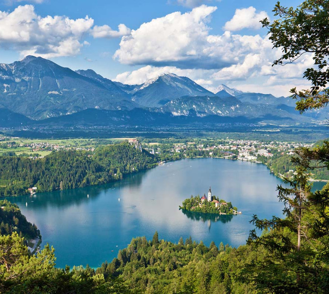 View from a hill of the island in the middle of the lake, with mountains in the background.