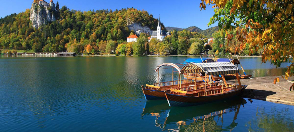 Pletna na jezeru, v ozadju Blejski grad.