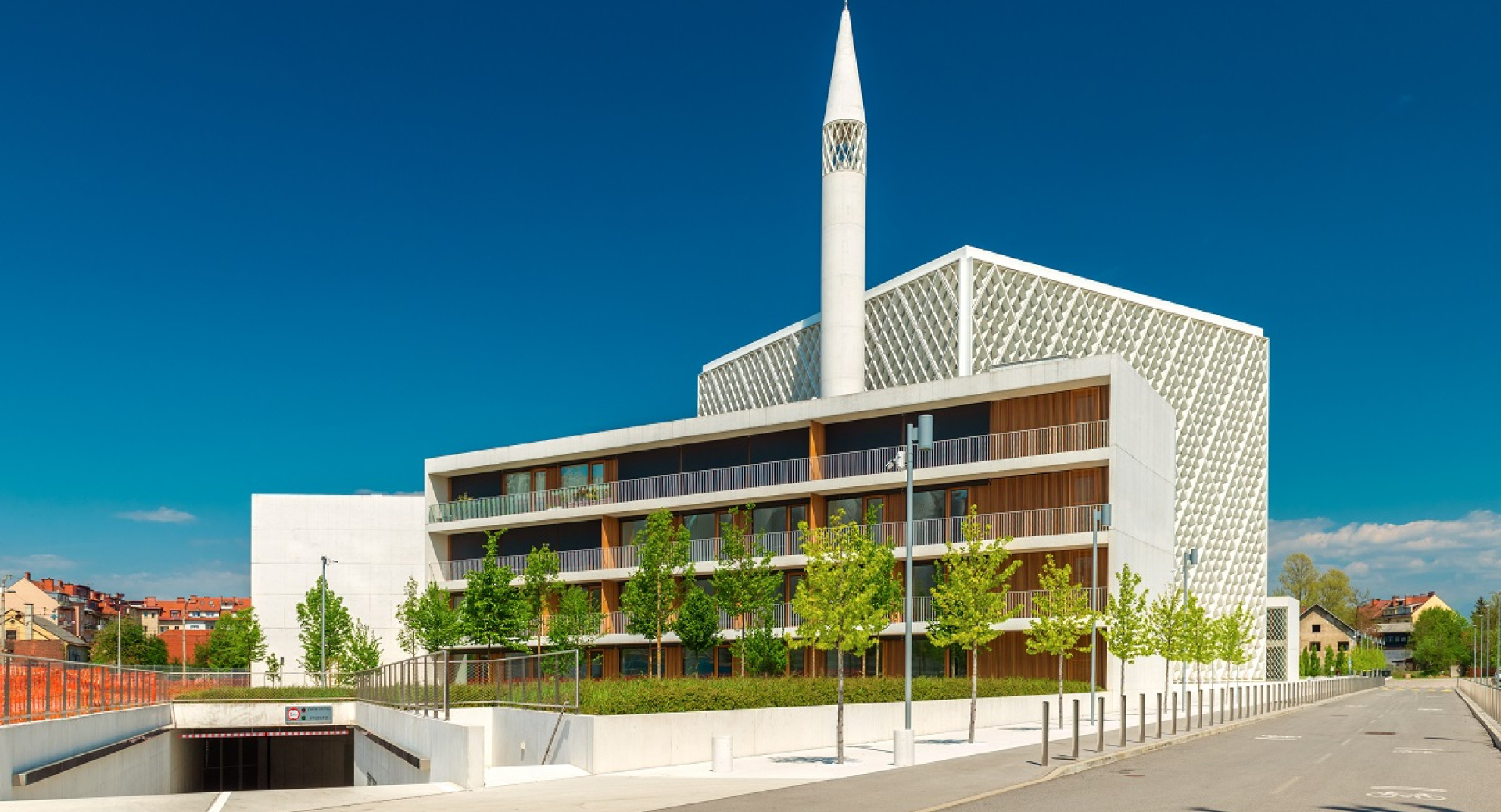 A large white building made of steel and exposed wood. Minaret in the middle.