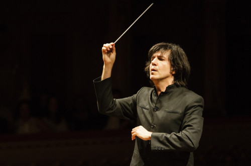 Dirigent v črnem suknjiču na koncertu.