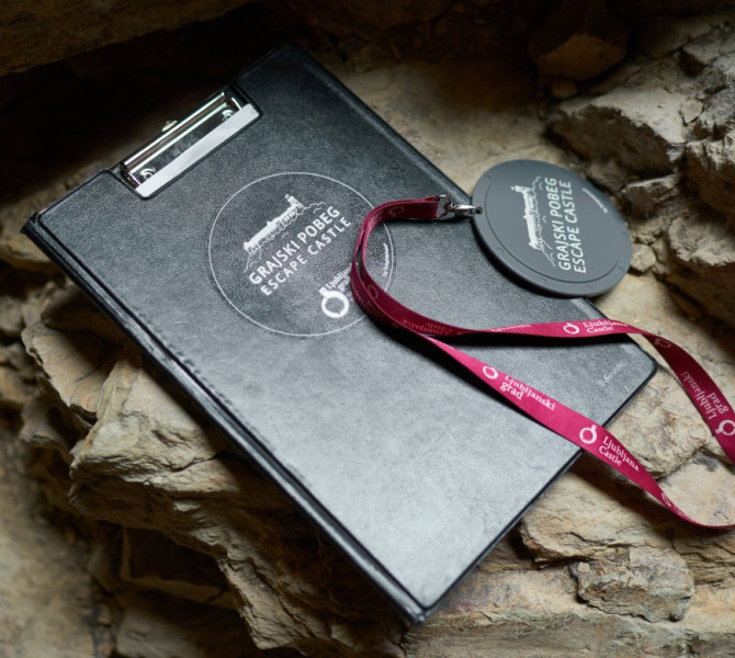 Knjiga igralnega nacrta in medaljon za igranje igre na Ljubljanskem gradu.