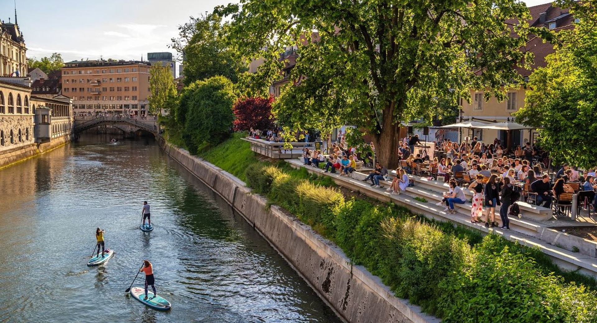 Supanje skozi Ljubljano, na desni strani ljudje na Petkovškovem nabrežju.