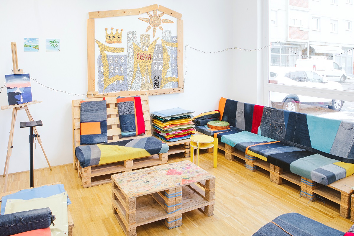 Soba za mlade z mizico iz palet in oblazinjeno sedezno iz palet.