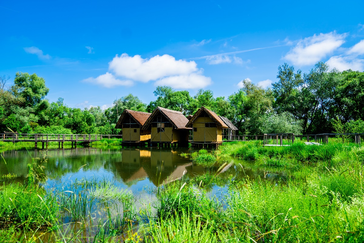 Three houses on piles surrounded by water.