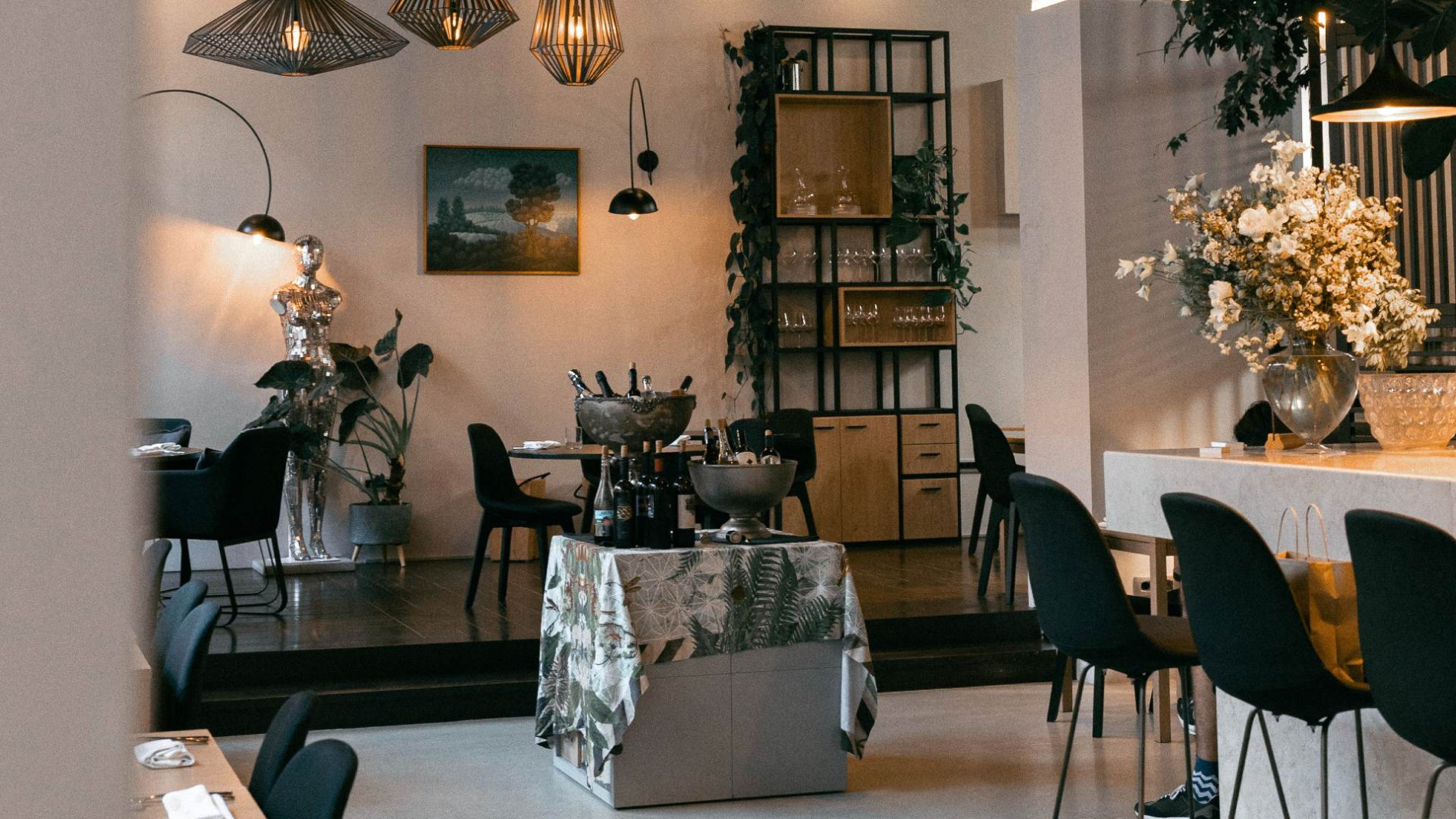 Modern restaurant in neutral, creamy tones with black furniture.