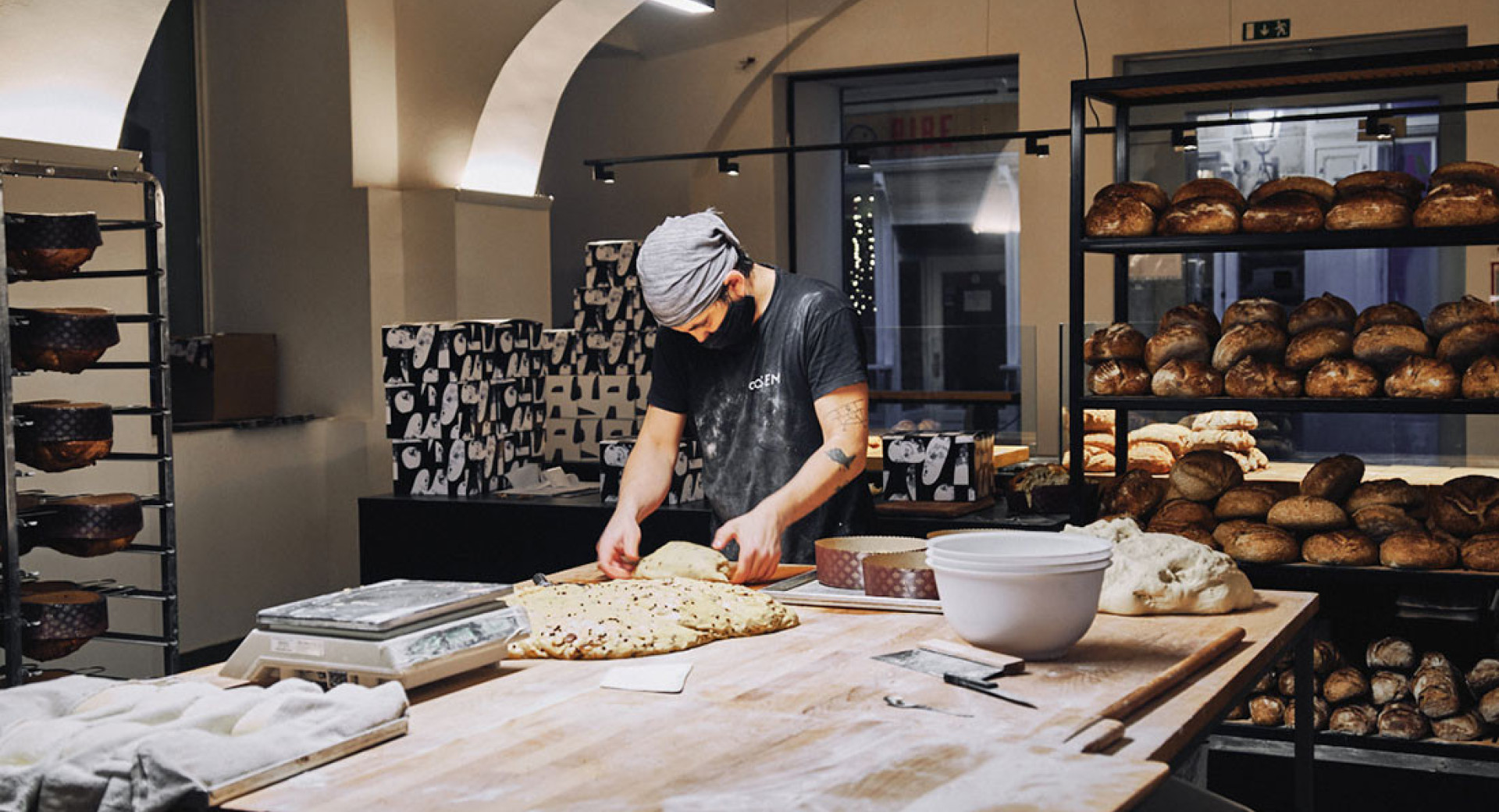 A person is preparing bread for baking.