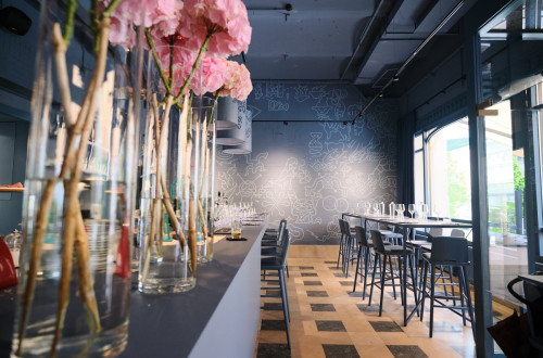 Inside of a restaurant. Dark background, long table, big glass windows.