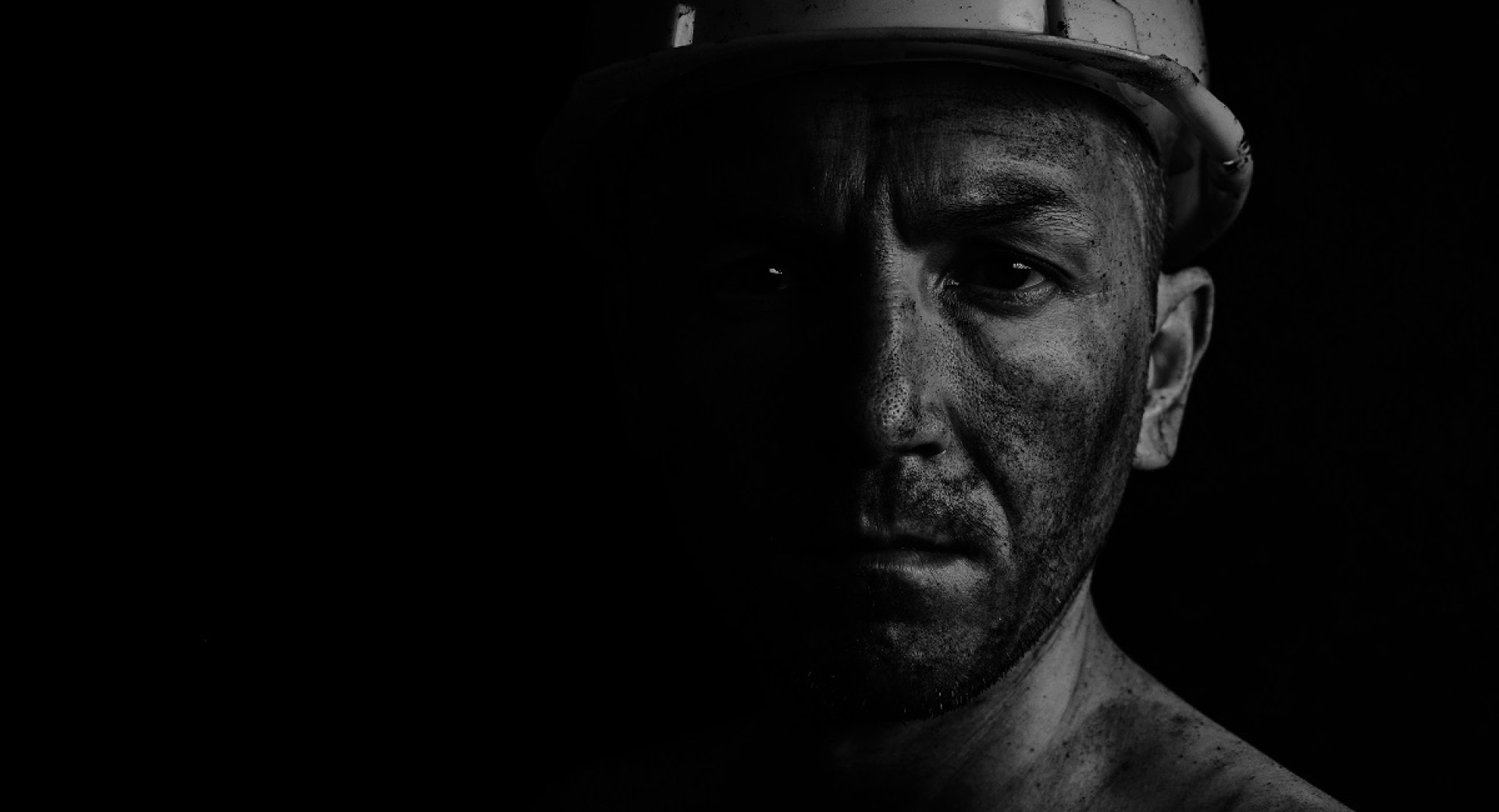 A dirty face of a miner on a black background.