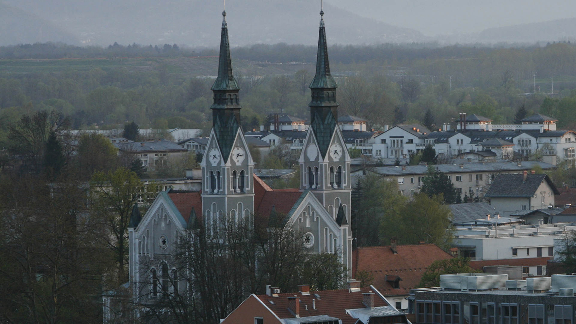 Cerkev sv. Janeza Krstnika in v ozadju okolica Trnova.