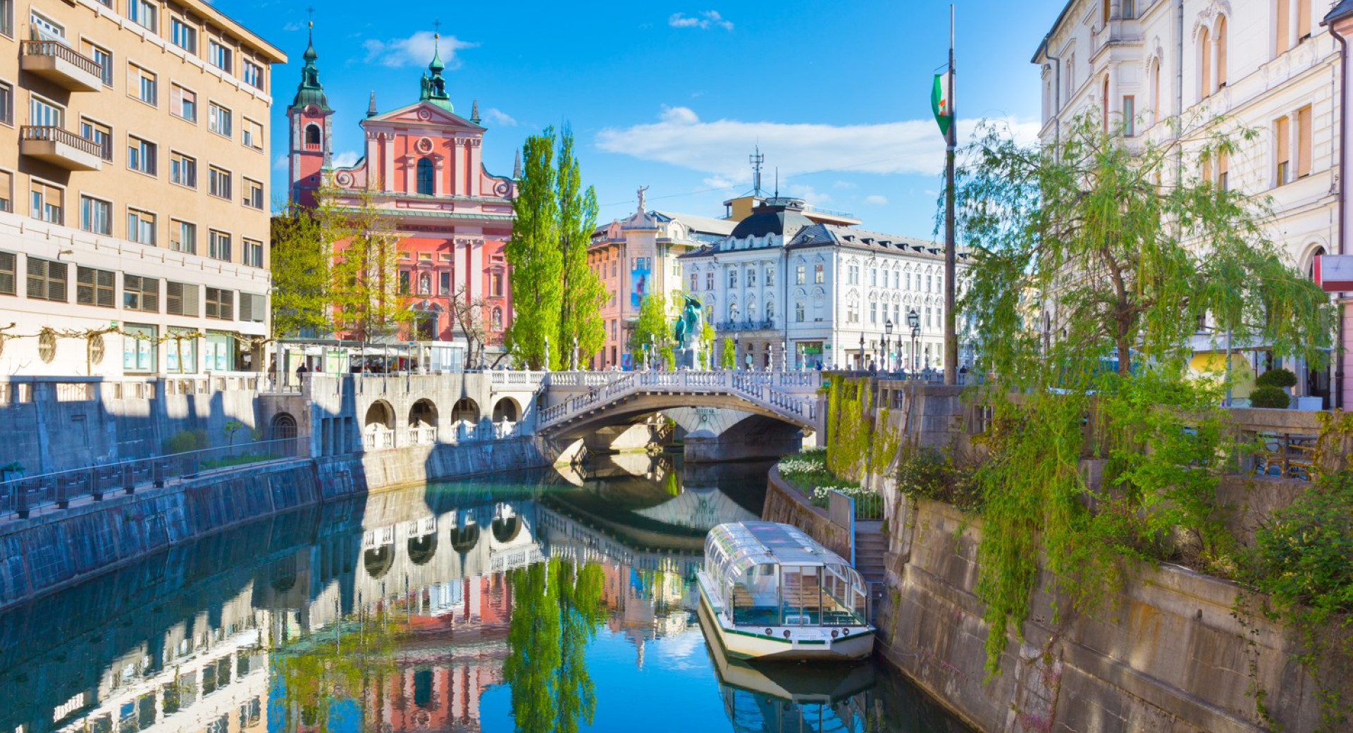 Ladjica na Ljubljanici. V ozadju Frančiškanska cerkev.