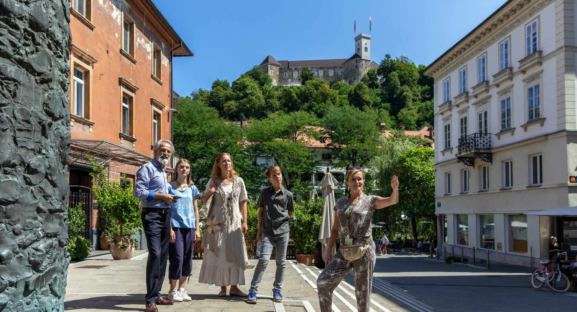 Family on a guided tour of Ljubljana, with Ljubljana Castle in the background.
