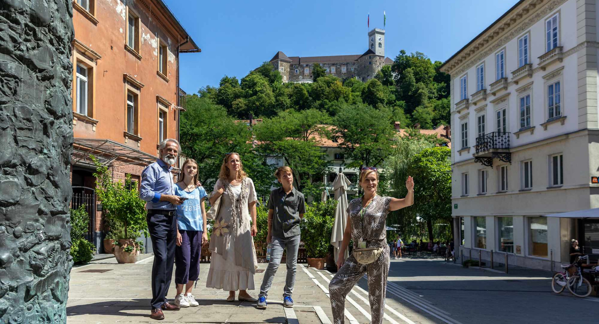 Turistično vodenje po Ljubljani v ozadju Ljubljanski grad.
