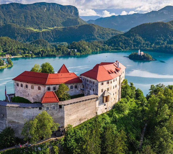 Panoramska slika Blejskega gradu. V ozadju jezero in otok.