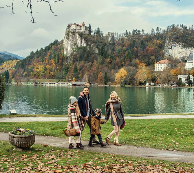 Una famiglia che passeggia lungo il Lago di Bled in autunno.