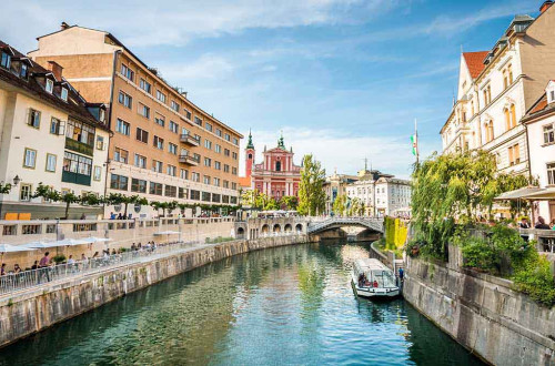 Ladjica na Ljubljanici. V ozadju Frančiškanska cerkev in Prešernov trg.