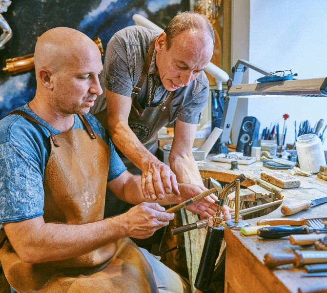 L’orafo aiuta un partecipante al laboratorio a creare un anello.