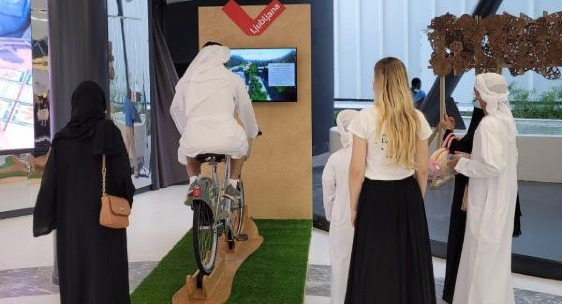 Obiskovalci preizkušajo virtualno izkušnjo kolesarja na Expo Dubai 2021.