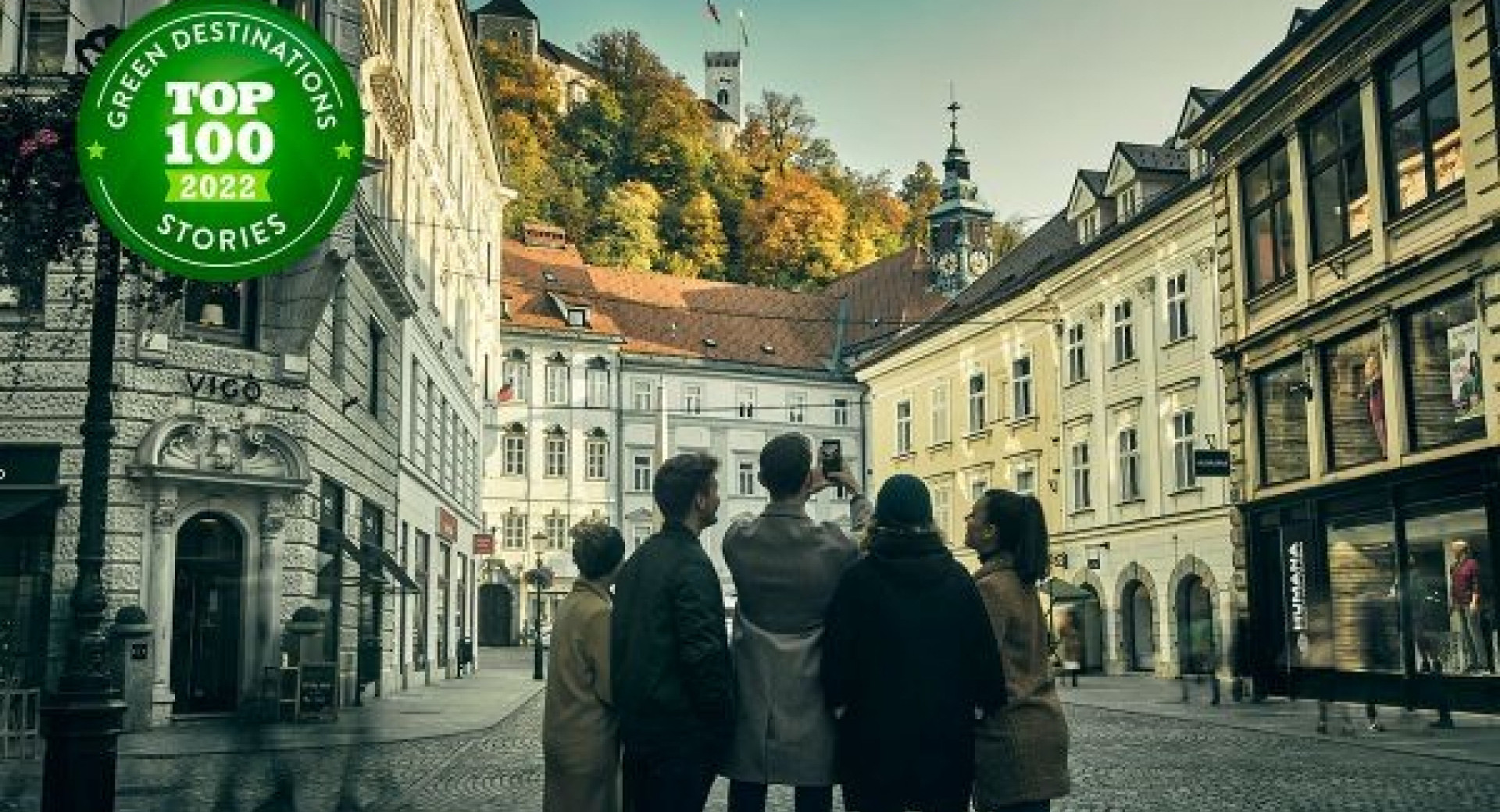 Skupina mladostnikov na Stritarjevi ulici fotografira Mestno hišo.