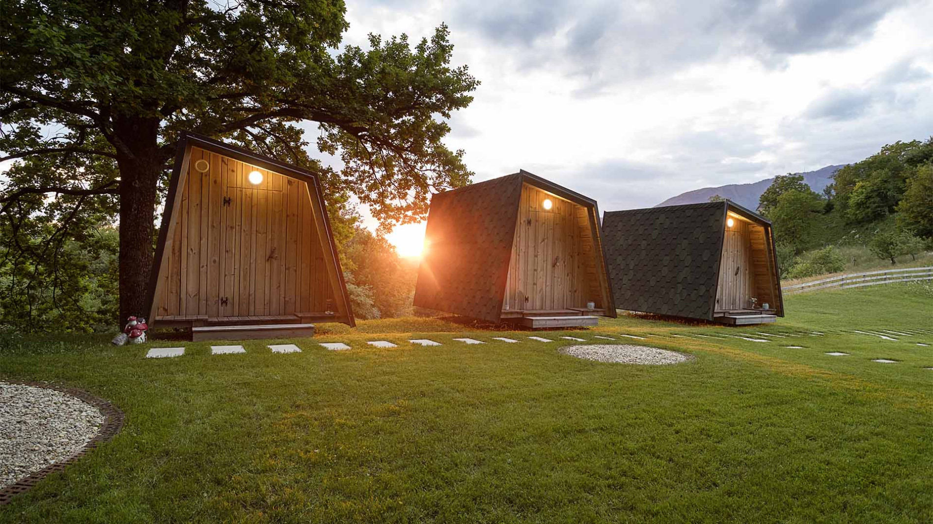 Glamping hiške na livadi ob sončnem zahodu.