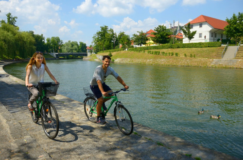 Kolesarja na nabrežju Ljubljanice.