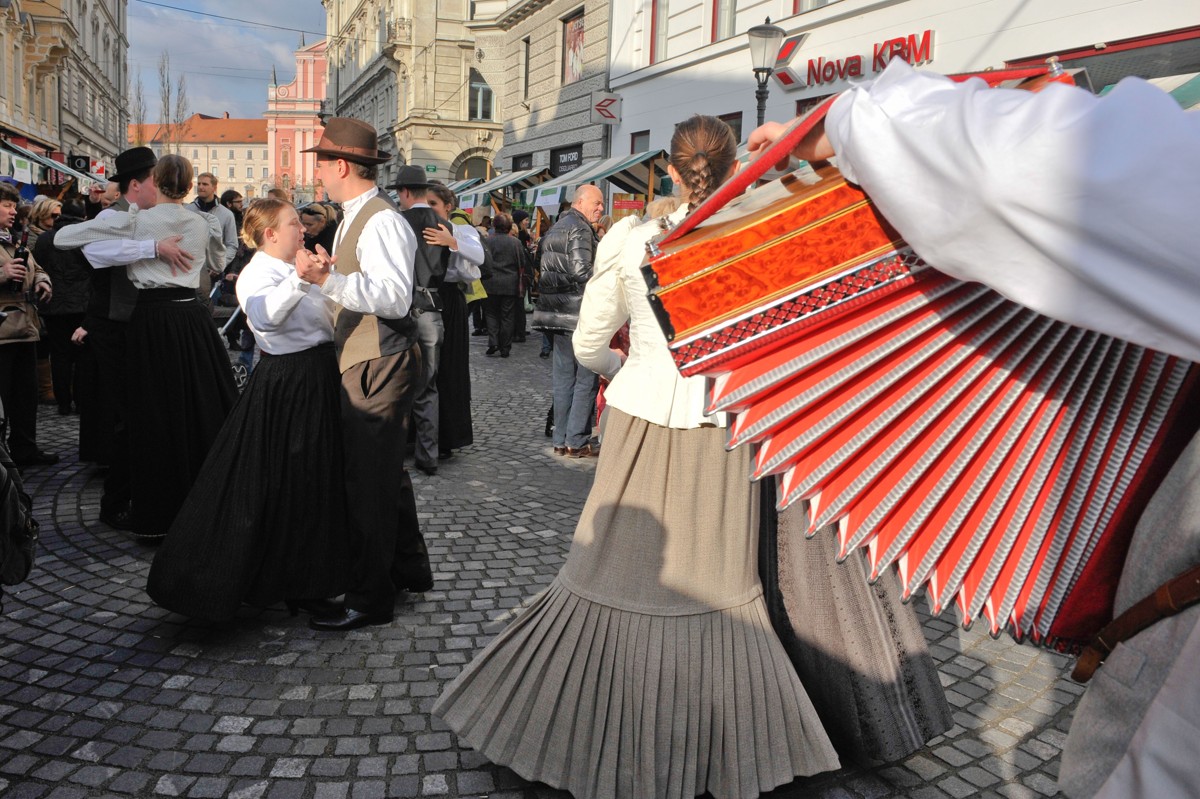 Plesalci folklore. V ospredju meh harmonike.