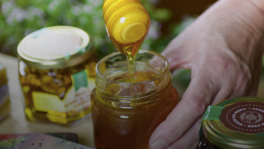 Dripping honey above a honey glass.