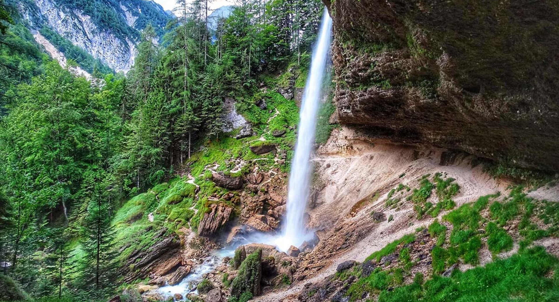 Peričnik Waterfall. Trees and mountains in the background.