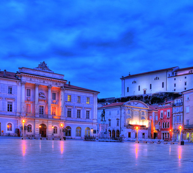 Una piazza circondata da edifici barocchi nel bagliore serale.