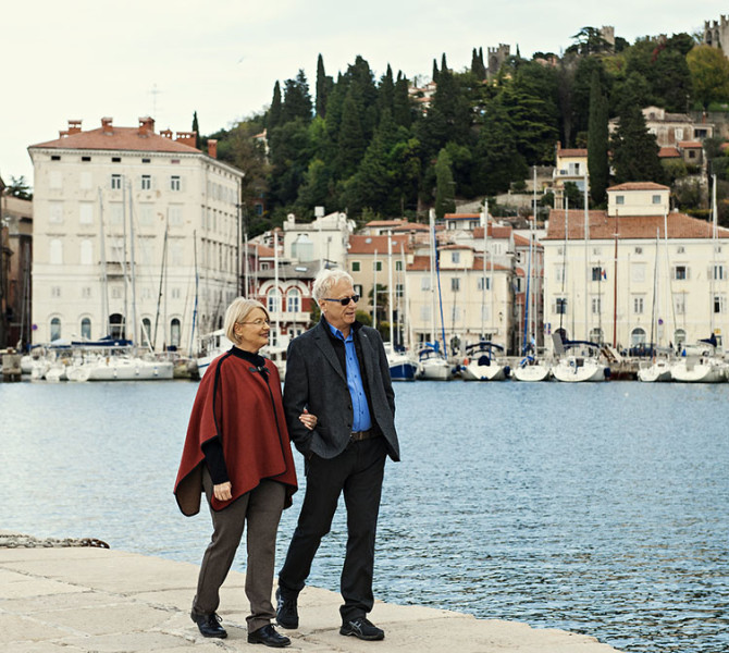 Turista ob morju. V ozadju barke in hiše.