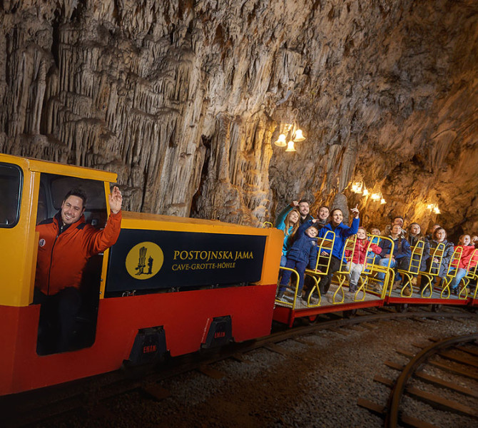 Turistični vlakec z gosti v jami.