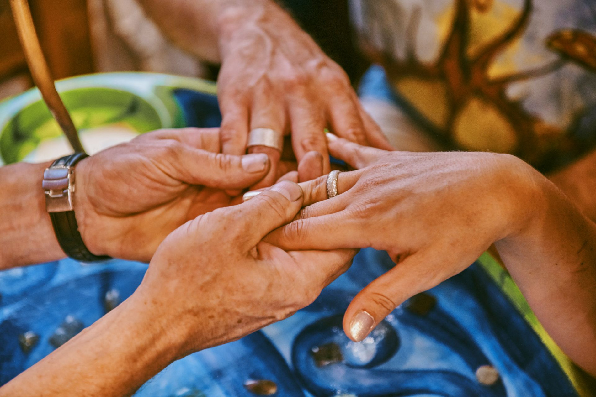 Rings on a women's and man's hand, held by a goldsmith.