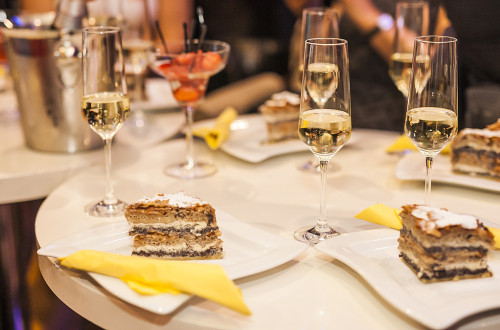 Prekmurska gibanica na krozniku, zraven kozarec belega vina.