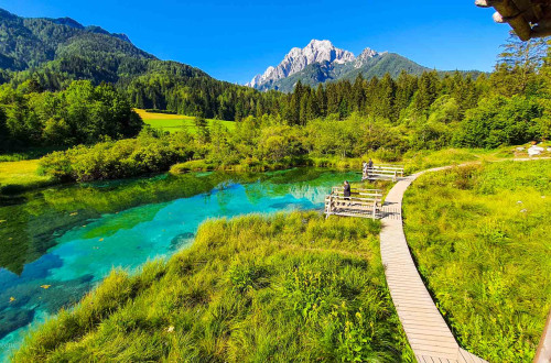 Emerald water in the nature and mountains in a distance.