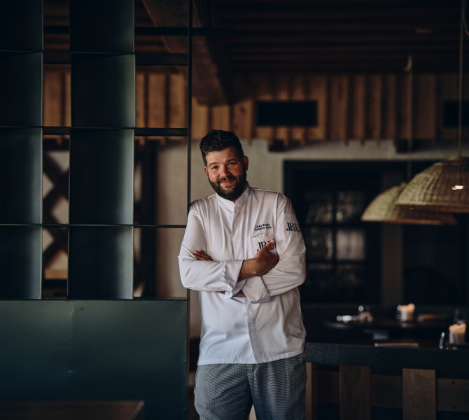 A chef in a restaurant posing for a photo.