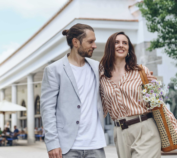Par se sprehaja, v ozadju arkade najbolj znanega slovenskega arhitekta.