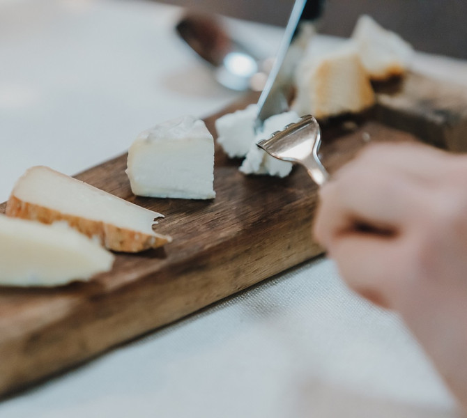 Assorted cheeses on a wooden board.