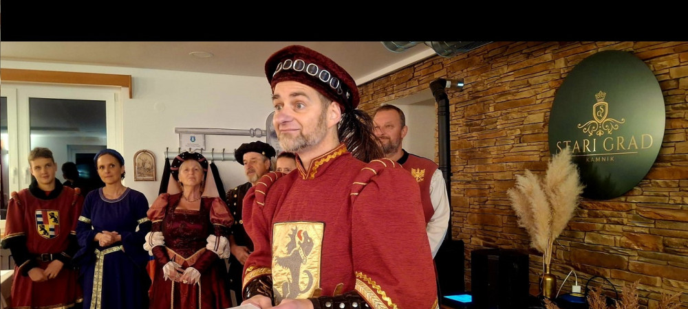 People dressed in red medieval costumes perform at the Old Castle above Kamnik.
