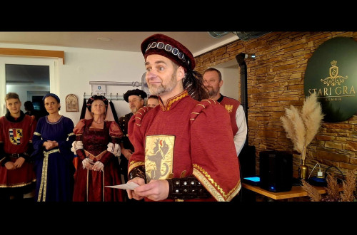 Ljudje v rdecih srednjeveskih oblacilih nastopajo v Starem gradu nad Kamnikom.