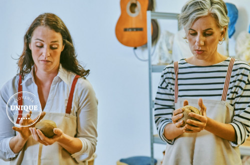 Two workshop participants are shaping clay.