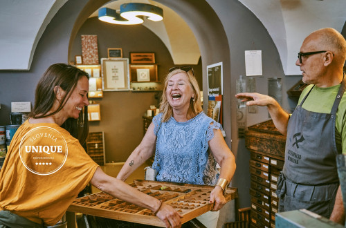 Visitors of the old printing press are preparing for printing.