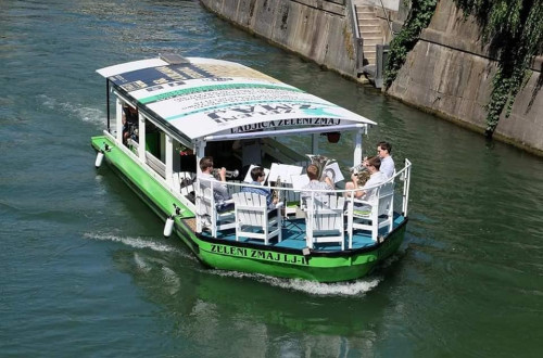 A bird’s-eye view of a boat on the Ljubljanica River, carrying a group of brass band musicians.